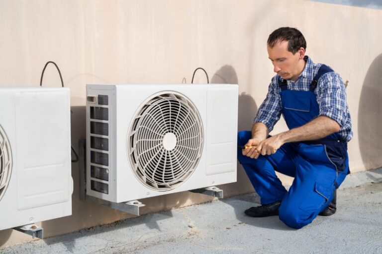 man works on heat pump